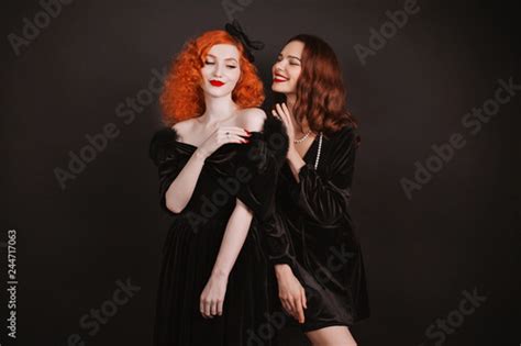 Two Young Lesbian Girls Couple With Curly Long Hair In Black Retro