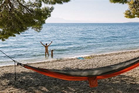 Naked Father And Son Standing In The Ocean By Stocksy Contributor