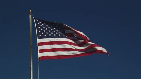 An American Flag Flying Against A Beautiful Blue Sky Stock Footage