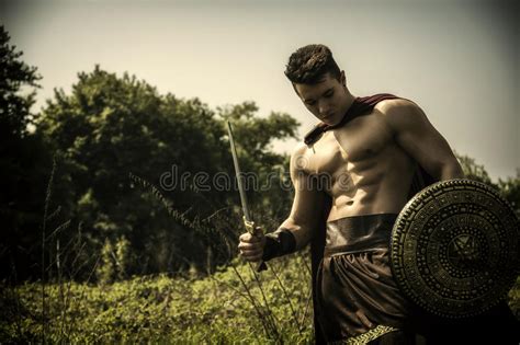 Hombre Muscular Joven Que Presenta En Traje Del Gladiador Foto De