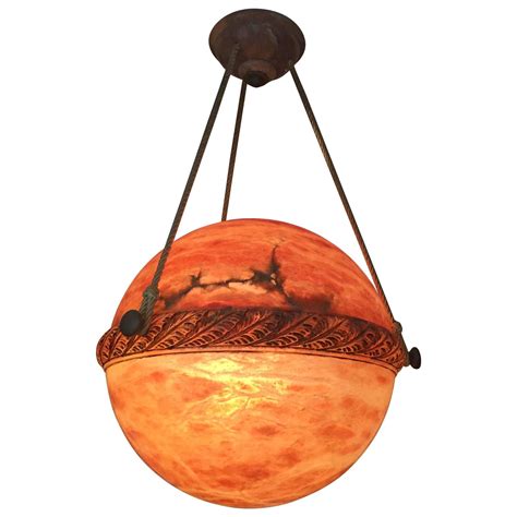It features brushed bronze hardware with gold accents, 5 lights encased in a frosted glass holder in a candelabra style setup. Alabaster Globe Style Chandelier at 1stdibs