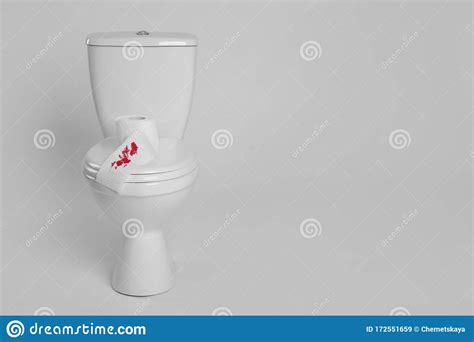Paper With Blood Stain On Toilet Bowl Against Background Hemorrhoids