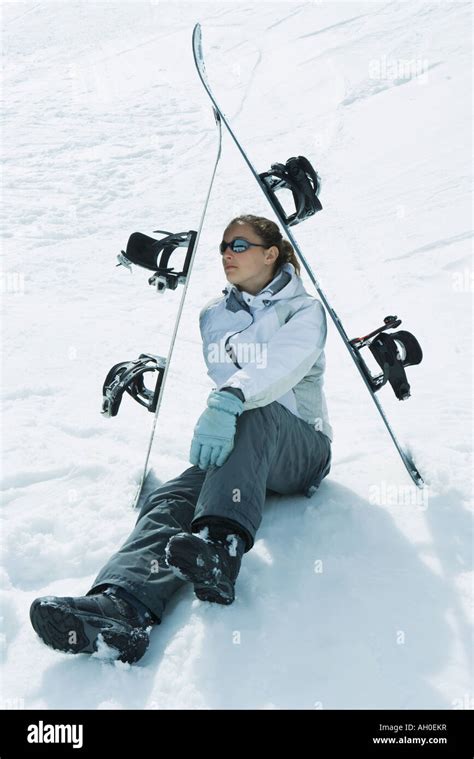 Young Female Skier Sitting On The Ground Under Skis Looking Away Stock