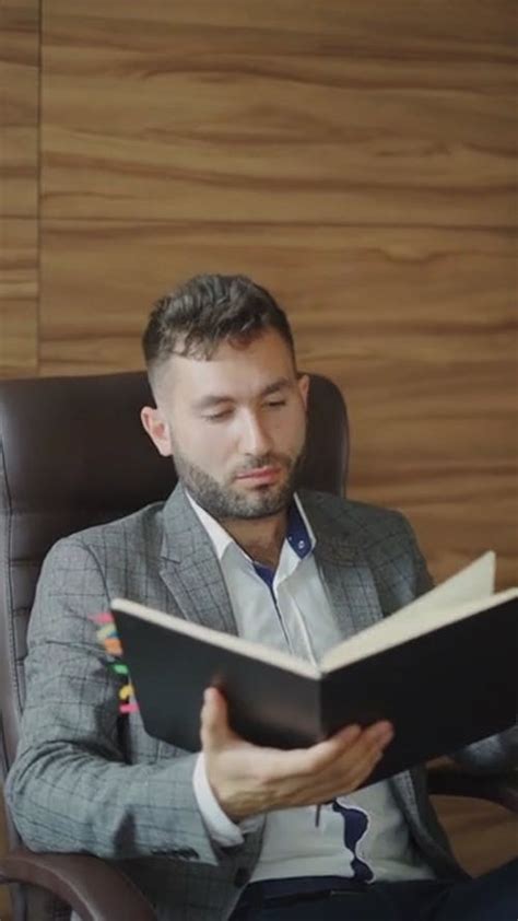 A Man Looking At His Watch While Reading A Planner · Free Stock Video