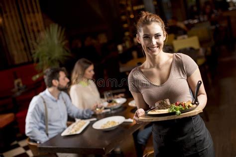 Waitress Holding A Wooden Plate With Beef Steak In The Restaurant Stock