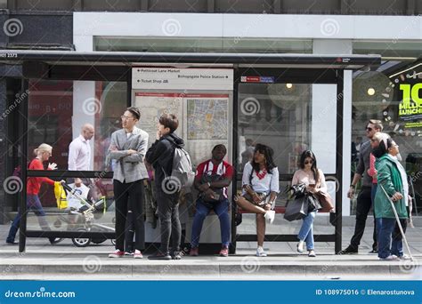 People Are Waiting For The Bus At The Bus Stop Representatives Of Different Nationalities Live