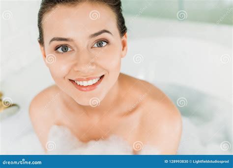 Beautiful Happy Young Woman Sitting In Bathtub With Foam And Smiling