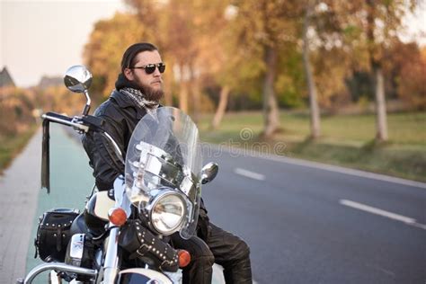 Bearded Biker In Black Leather Jacket On Modern Motorcycle On Country