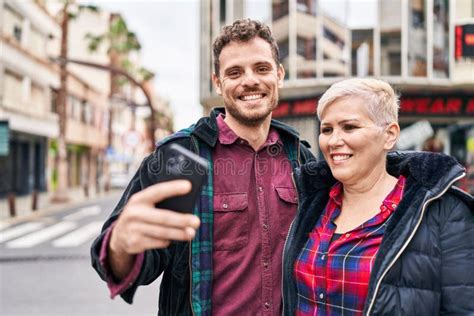 Mother And Son Smiling Confident Using Smartphone At Street Stock Photo