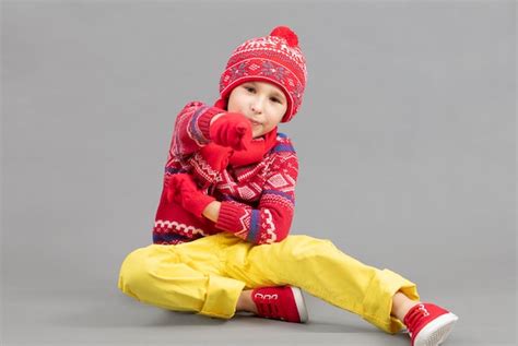 Premium Photo Child In Warm Knitted Clothes On A Studio Background A