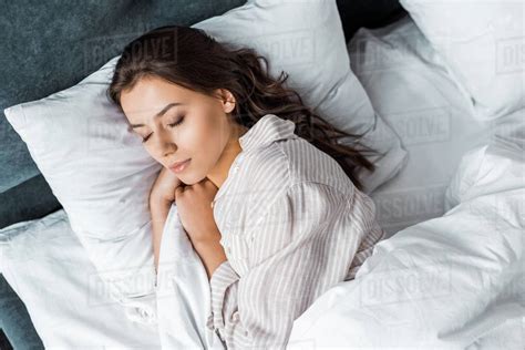 Beautiful Brunette Girl In Pajamas Sleeping On Bed Stock Photo Dissolve