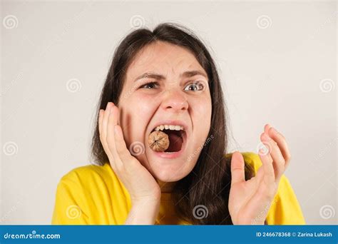 A Woman Gnaws On A Walnut Opening Her Mouth Wide Breaking A Tooth Or