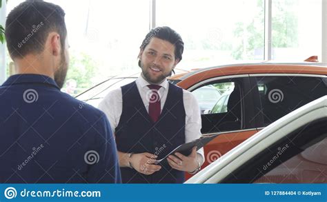 Handsome Male Car Dealer Talking To His Male Customer Stock Photo