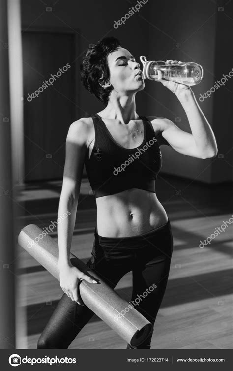 Woman With Yoga Mat Drinking Water — Stock Photo © Arturverkhovetskiy