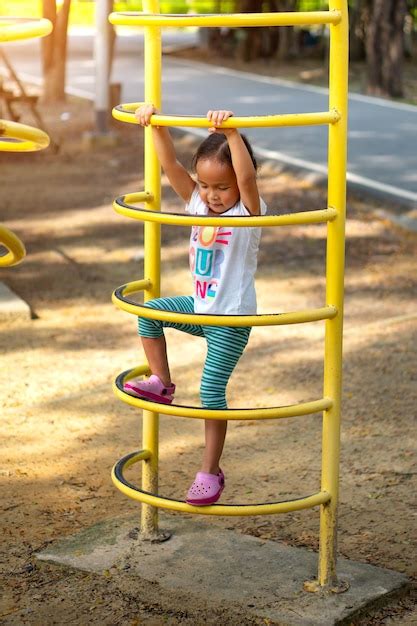 Premium Photo An Asian Girl Is Climbing On A Playground Equipment In A School