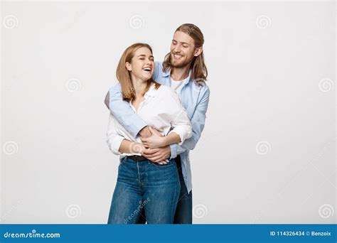 Portrait Of Cheerful Young Couple Standing And Hugging Each Other On
