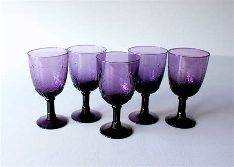 Five Purple Wine Glasses Lined Up In A Row