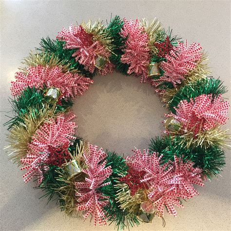 A Pink And Green Christmas Wreath On A Table
