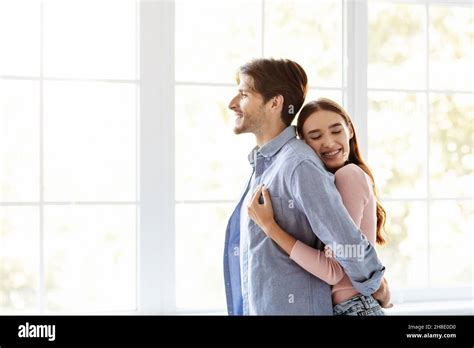 Smiling Millennial European Man Look Outside Woman Hugs Her Husband