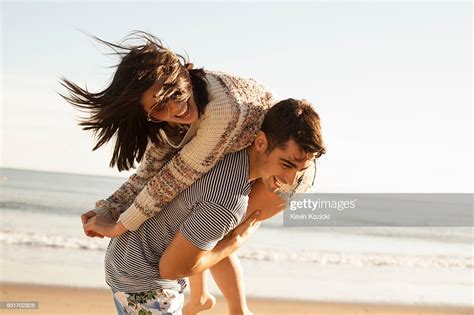 Young Couple Fooling Around On Beach Photo Getty Images