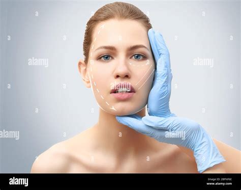 Plastic Surgery Concept Doctor Examining Female Face Light Background