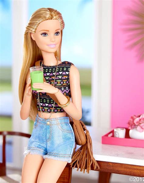 A Barbie Doll Holding A Green Drink In Her Hand