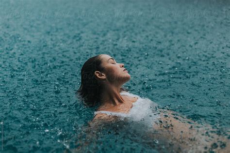 Woman In A Pool Swimming In The Rain By Jessica Lia Stocksy United