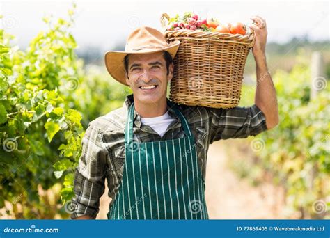 Portrait Of Happy Farmer Carrying A Basket Of Vegetables Stock Image