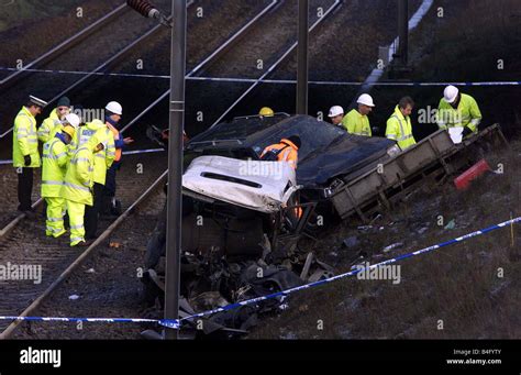 Accident Investigators Look Through Car That Fell Off The Bridge On To The Track Derailing The