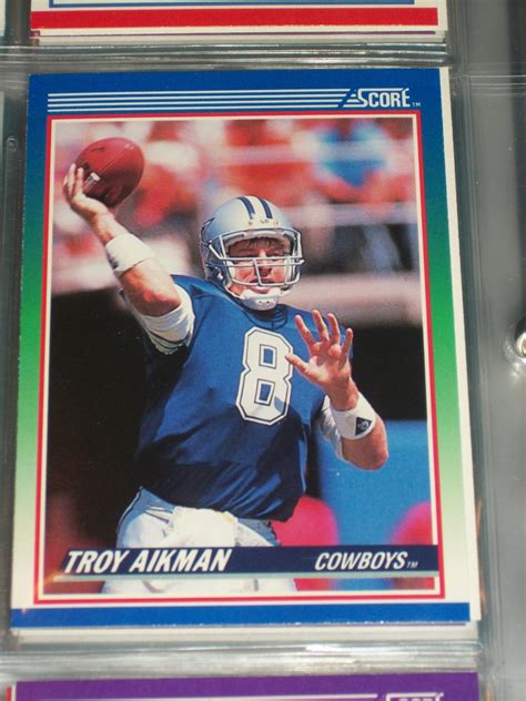 The fronts have sharp color action photos and multicolored borders. Troy Aikman 1990 Score football card
