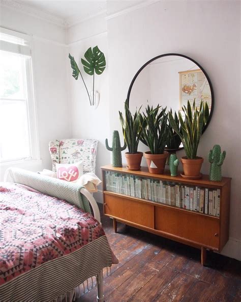 Very bohemian and easy to add to any room, vines are definitely an addition to consider. Boho bedroom with round mirror and snake plants (which ...