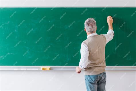 Premium Photo Senior Male Professor Writing On Blackboard With Chalk