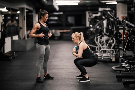 Premium Photo A Female Personal Trainer Is Explaining How To Do