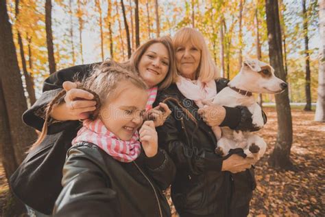 Three Generations Of Women And Dog Feel Fun Look At Camera Posing For