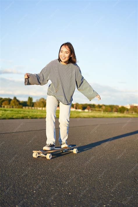 cute asian girl riding skateboard patinage sur route et patineur souriant sur cruiser longboard