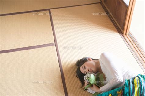 花を持ち畳に寝転がる女性[02299006113]の写真素材・イラスト素材｜アマナイメージズ
