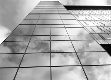 View Of A Modern Glass Skyscraper A Reflection Of The Cloudy Sky In A