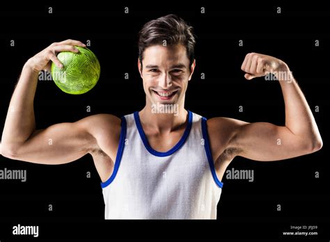 Portrait Of Happy Athlete Man Holding Ball And Showing Muscles Stock