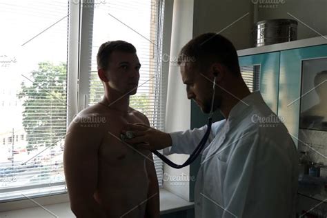 Doctor Examining Young Male Patient With Stethoscope Medical Worker