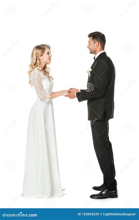 Happy Young Bride And Groom Holding Hands And Looking At Each Other