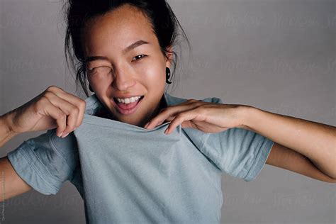 Korean Girl Taking Off T Shirt And Squinting At Camera By Stocksy Contributor Danil Nevsky