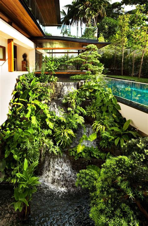 A Landscaping Design Feature Of This Modern House Is A Waterfall