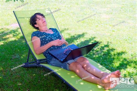Happy Mature Woman Relaxing Resting On The Deck Chair In The Garden Stock Photo Picture And