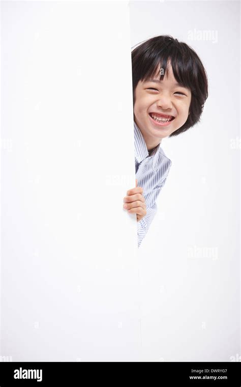 A Kid Hiding Behind A White Wall Stock Photo Alamy
