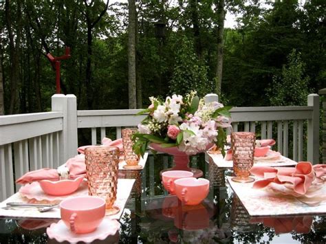 The Table Is Set With Pink And White Dishes Cups And Saucers On It