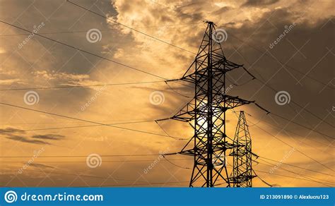 Electricity Pylons And High Voltage Power Line At Sunset Stock Photo