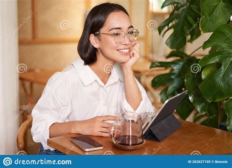 Smiling Asian Girl In Glasses Woman Working On Remote Drinking Coffee