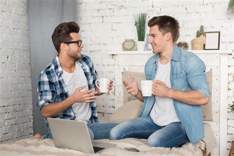 Male Partners Talking And Drinking Coffee Together Stock