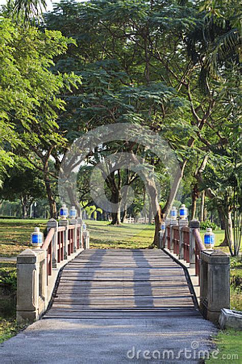 Beautiful Perspective Wood Bridge Crossing Water Pool In Public Park