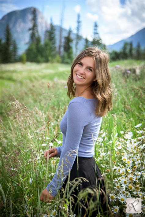 Outdoor Senior Pictrures Girl Smiling In Field With Mountains In